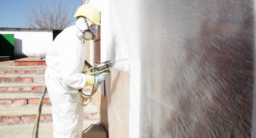 Operario inyectando espuma de poliuretano en la rehabilitación de una vivienda